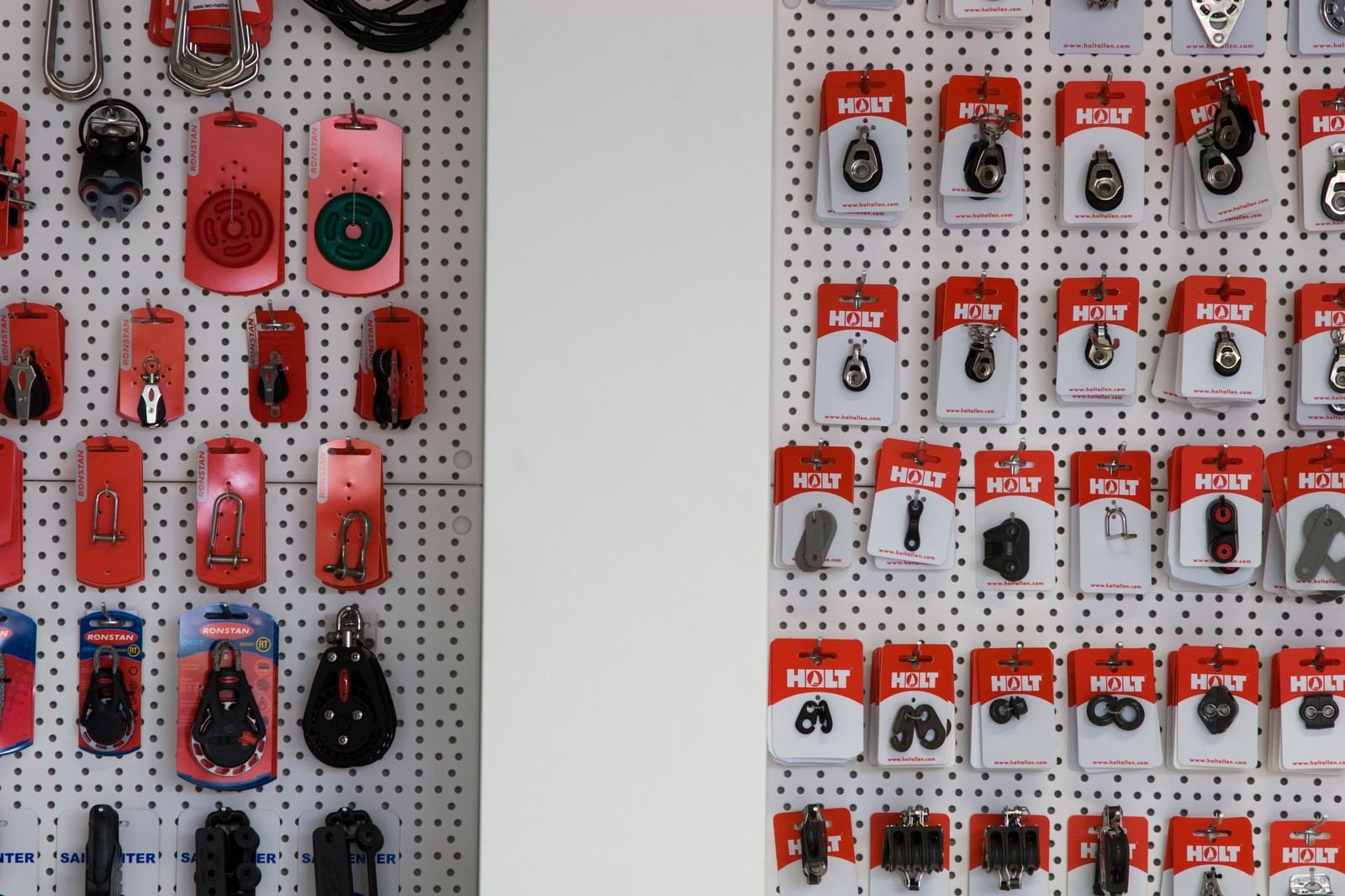 Witte pegboardpanelen met kleurrijke rijen zeilbeslag in blisterverpakkingen.