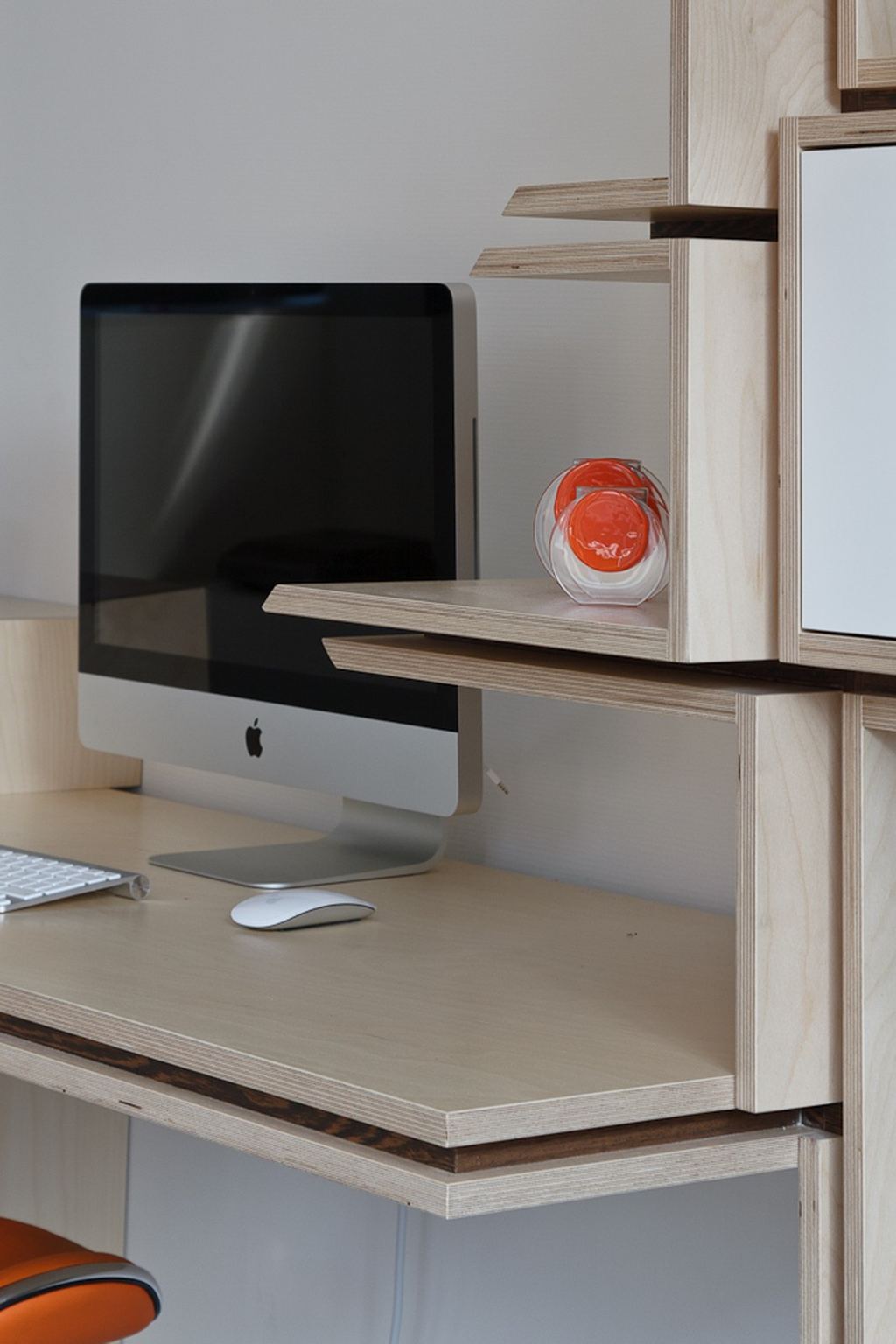 Detail van een licht houten bureau met een klein uitkragend plankje ernaast.