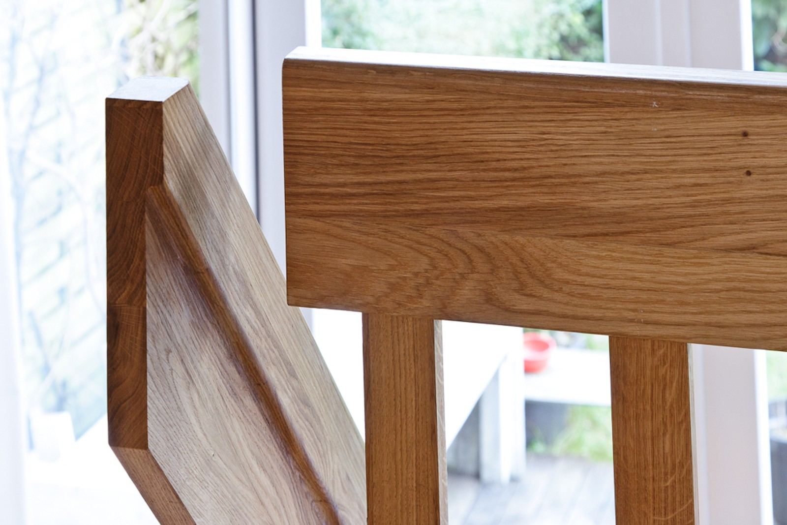 Detail van de massief eiken trapleuning en de verticale spijlen.