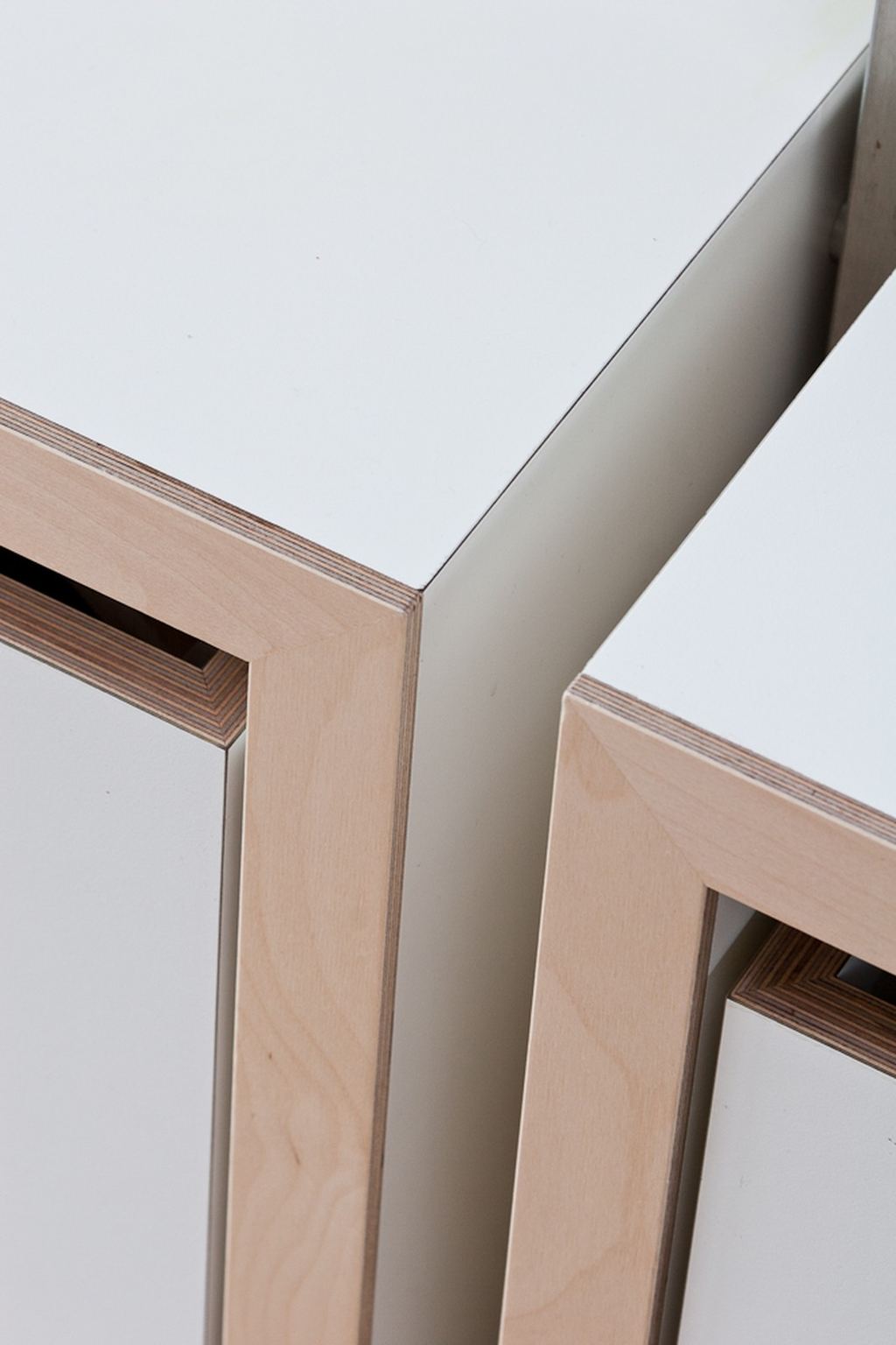 Detail van twee houten kasthoeken die tegen hetzelfde witte tussenschot aansluiten.