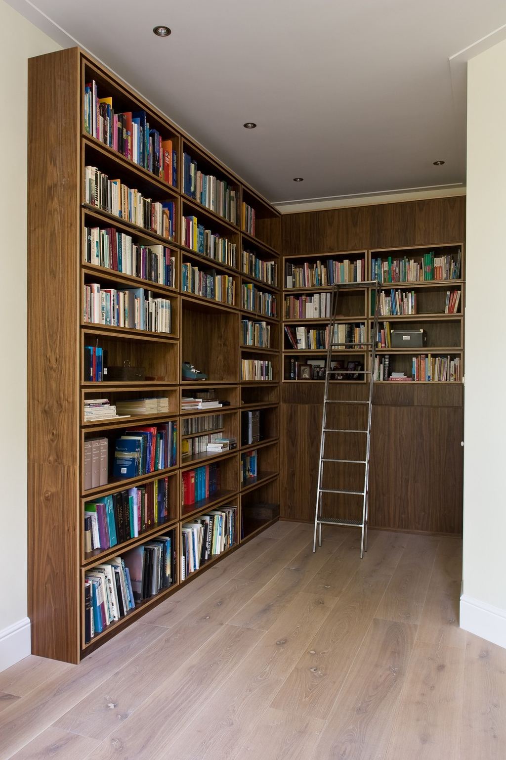 Boekenkast in notenfineer die om de hoek doorloopt.