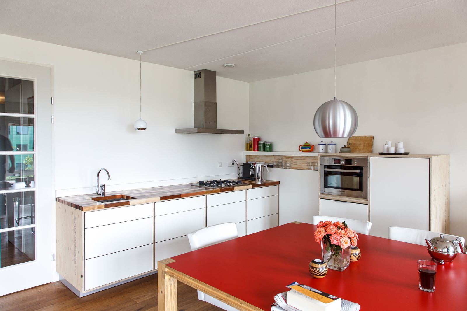 Keuken met witte kastfronten en een werkblad van houten stroken in verschillende kleuren.
