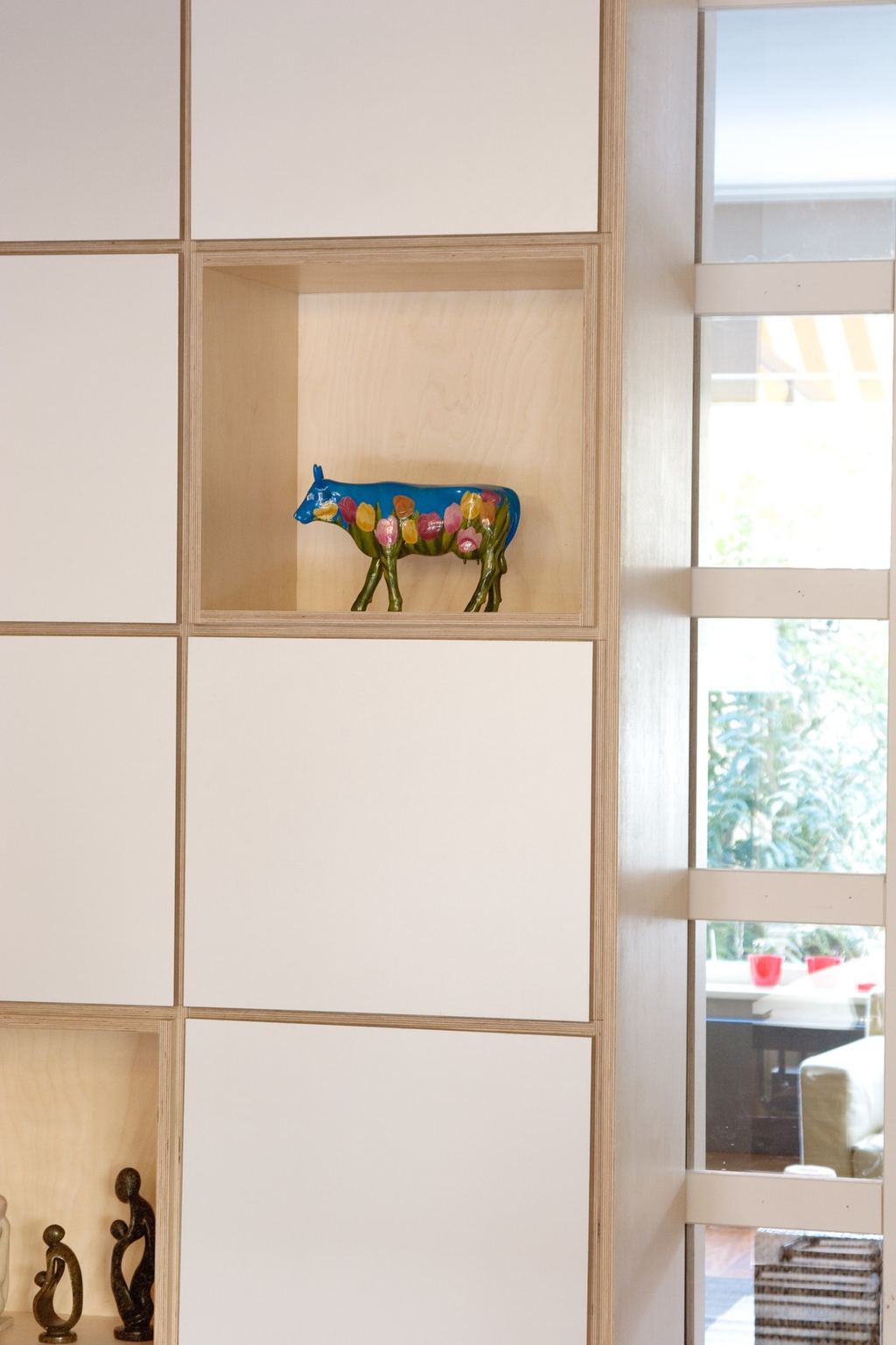 Open vak van de kast met een kleurrijk koebeeldje.