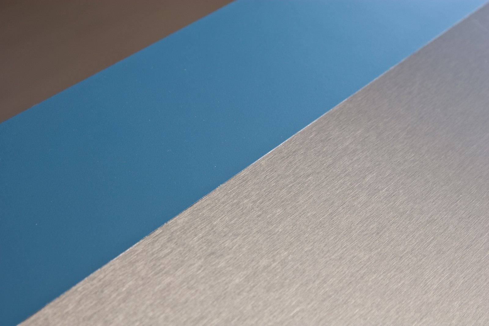 Detail van de overgang tussen blauw HPL, aluminium en vuren multiplex.