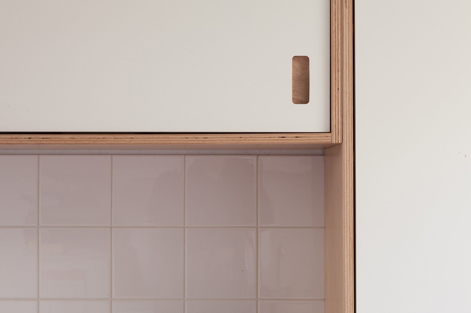 Detail van een schuifdeur in wit HPL met een greepuitfrezing.