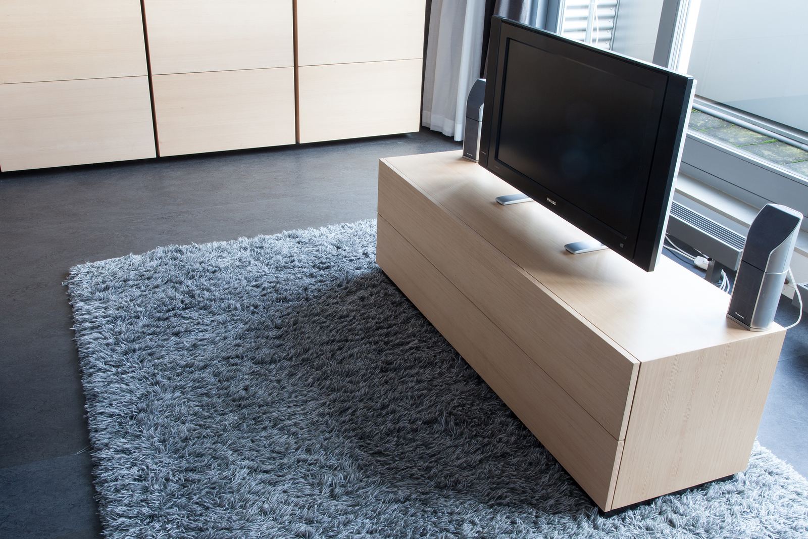 Laag eiken tv-meubel met televisie voor de garderobekast.